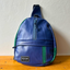 A sustainable blue crossbody bag with green details from pineapple-fiber leather.