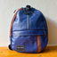 A sustainable blue crossbody bag with café (light brown) details from pineapple-fiber leather.