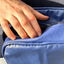 Reaching a hand into a Wearsos upcycled blue toiletry bag.